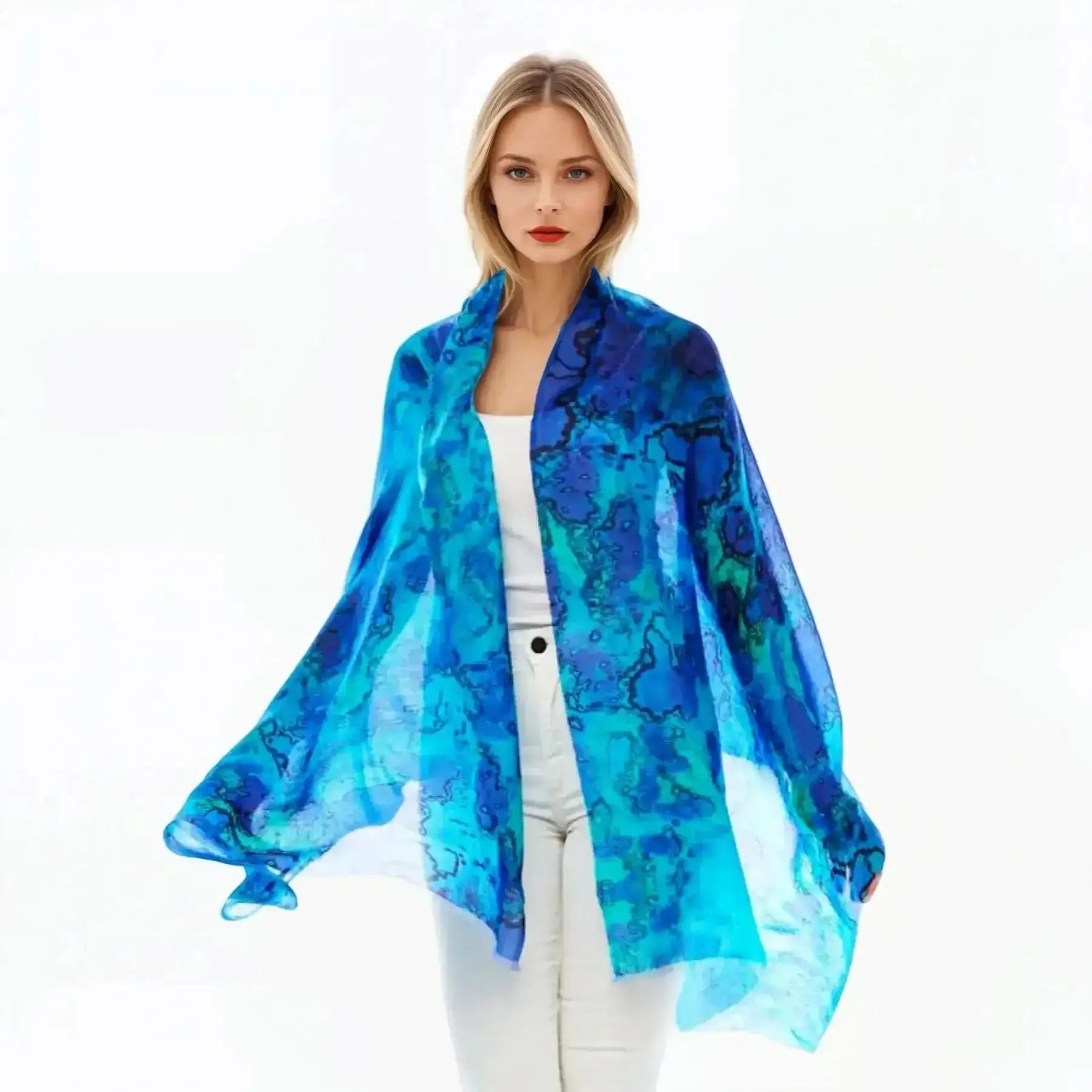 Woman wearing a blue silk scarf from Claire Powell, styled with white top and pants