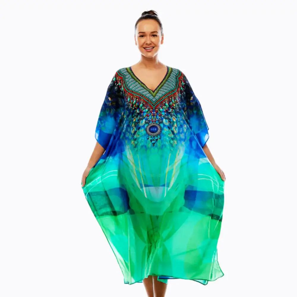Woman wearing Claire Powell tribal print kaftan dress in blue and green on white background