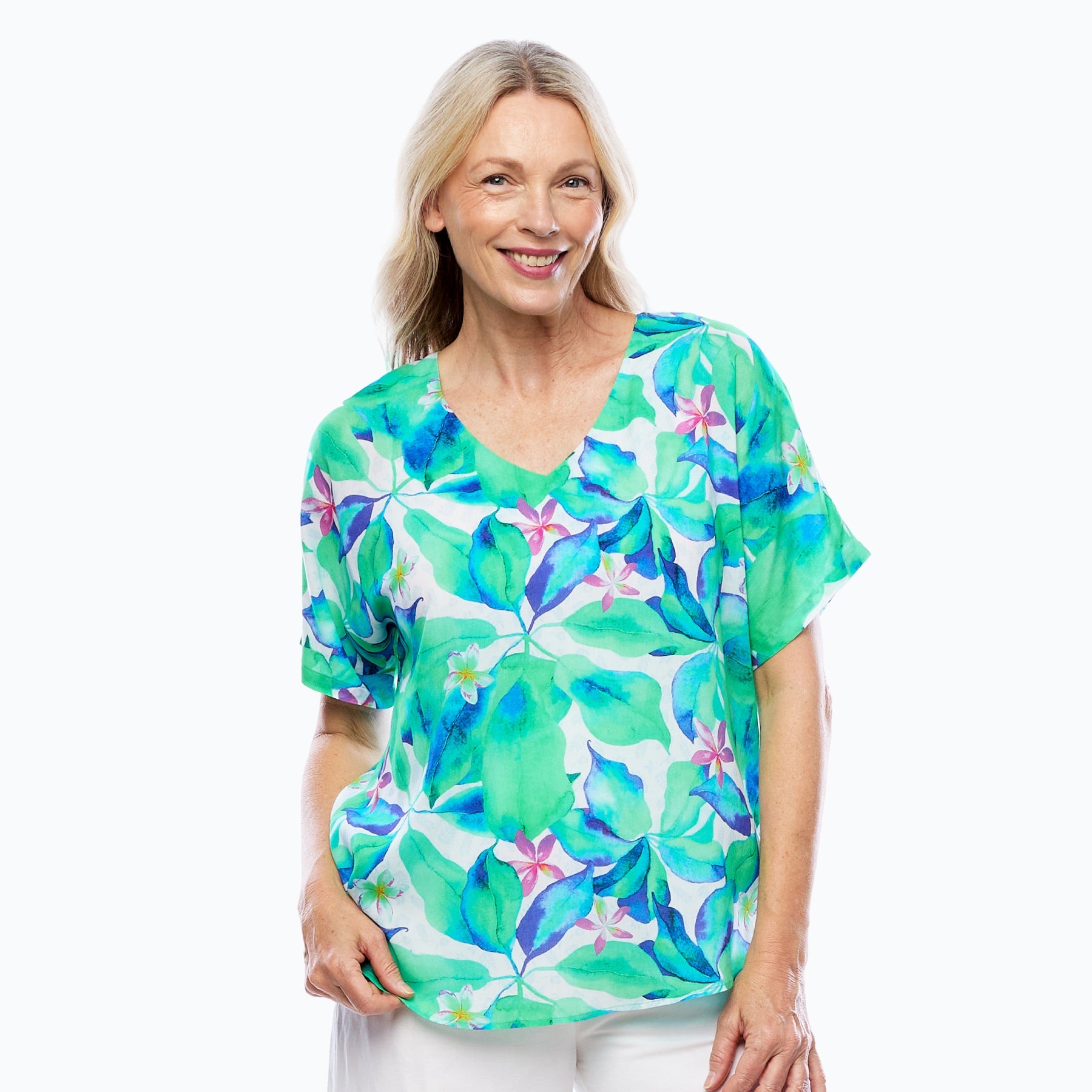 Woman wearing Claire Powell eco-friendly floral print top and white pants, stylish women's clothing