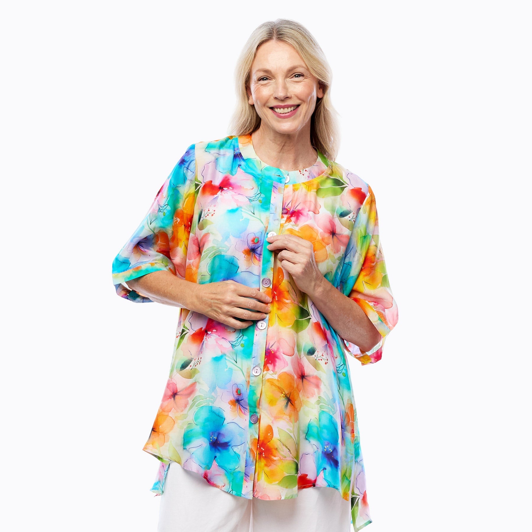 Woman wearing a colorful floral button-up blouse by Claire Powell, eco-friendly women's clothing