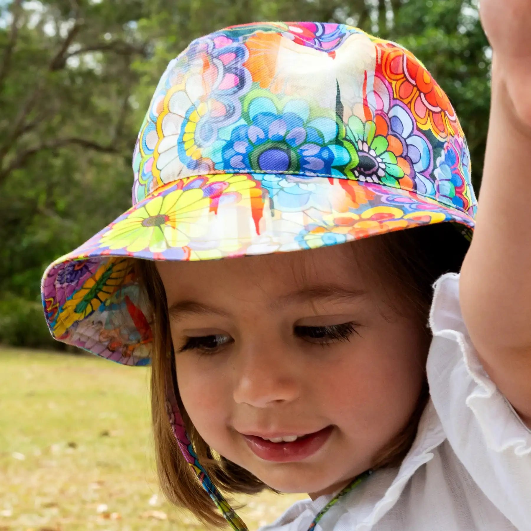 Child wearing a colorful floral bucket hat outdoors