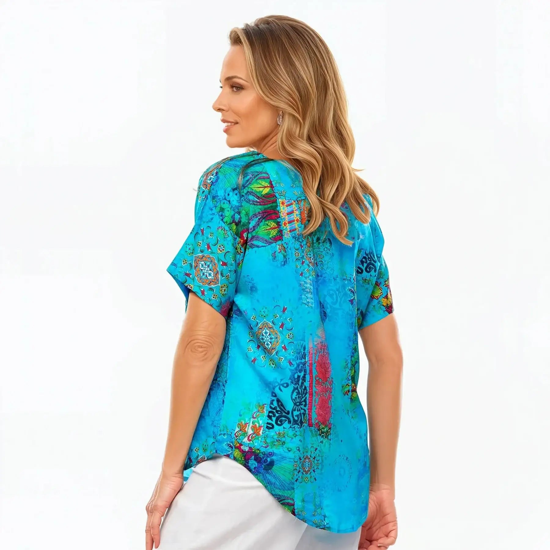 Woman wearing a vibrant blue patterned V-neck t-shirt from Claire Powell, side view.