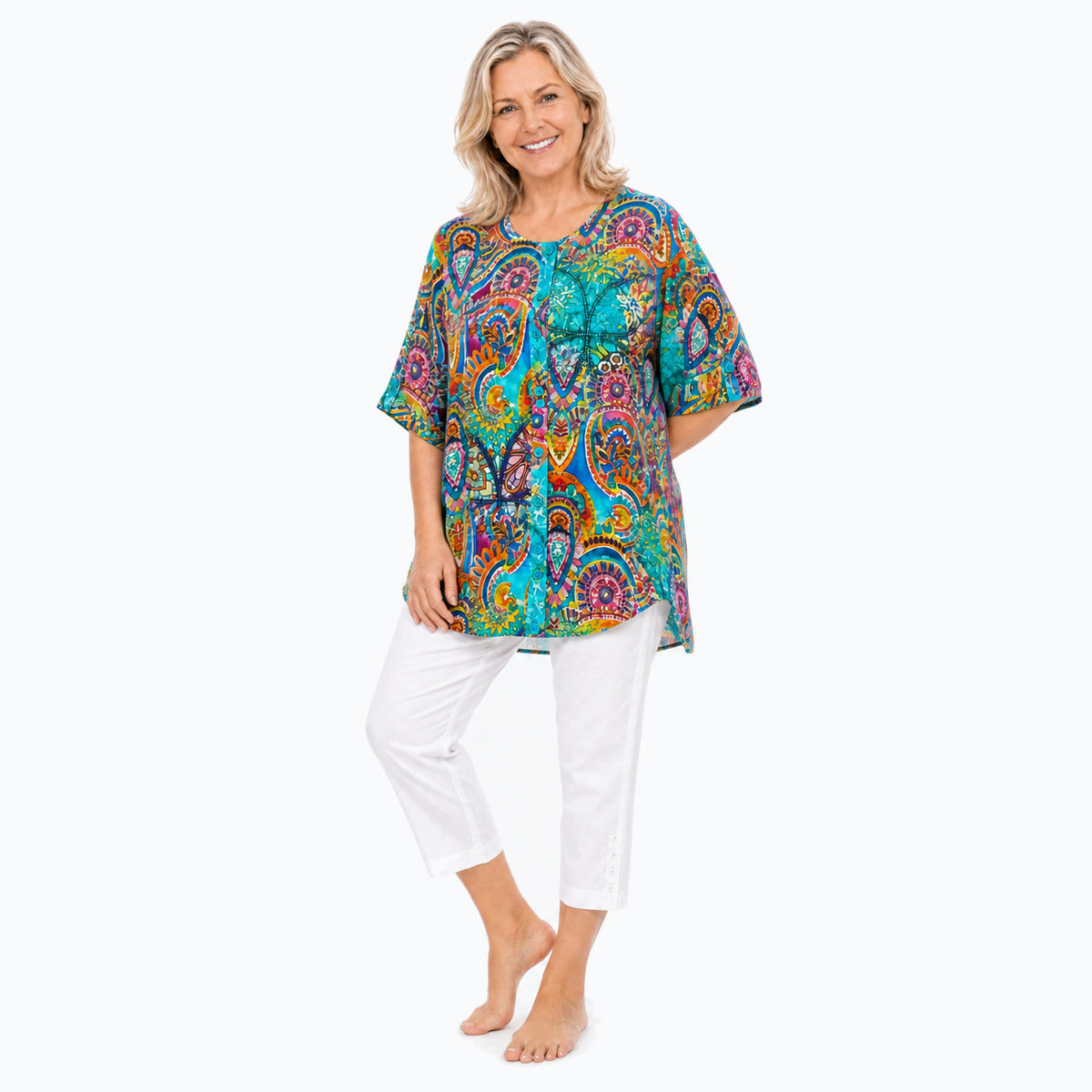 Woman wearing the Claire Powell Mosaic A-Line Tunic Shirt with white capri pants, barefoot full-body three-quarter view