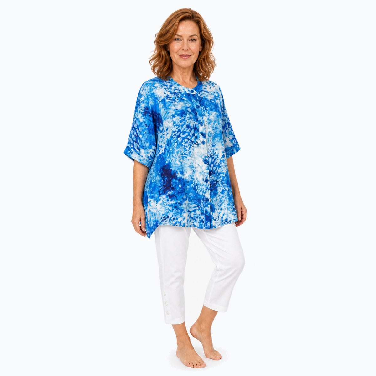 Woman wearing the Claire Powell Snowcat A-Line Tunic Shirt with white capris, barefoot three-quarter full-body view