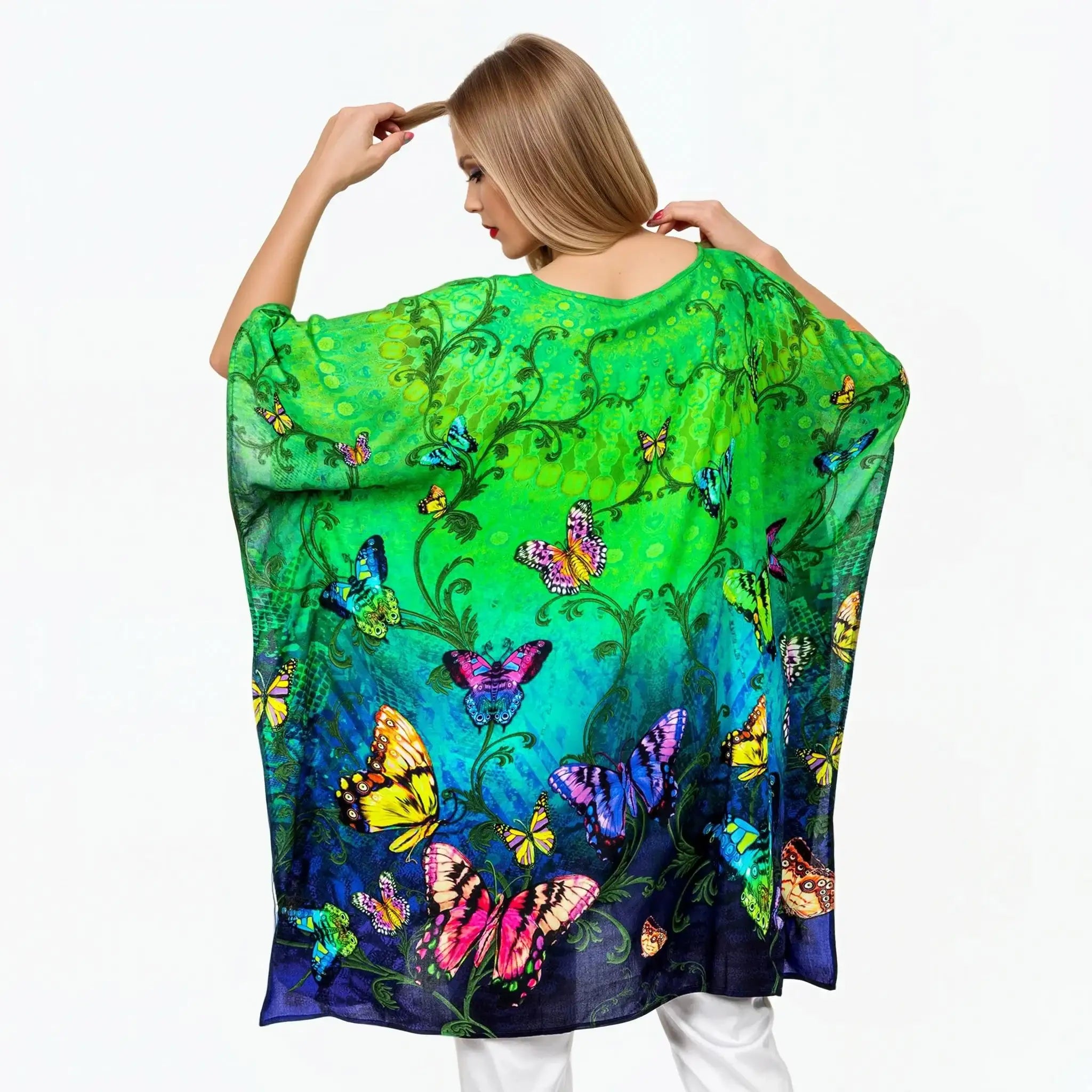 Woman wearing a vibrant butterfly print green mini kaftan by Claire Powell