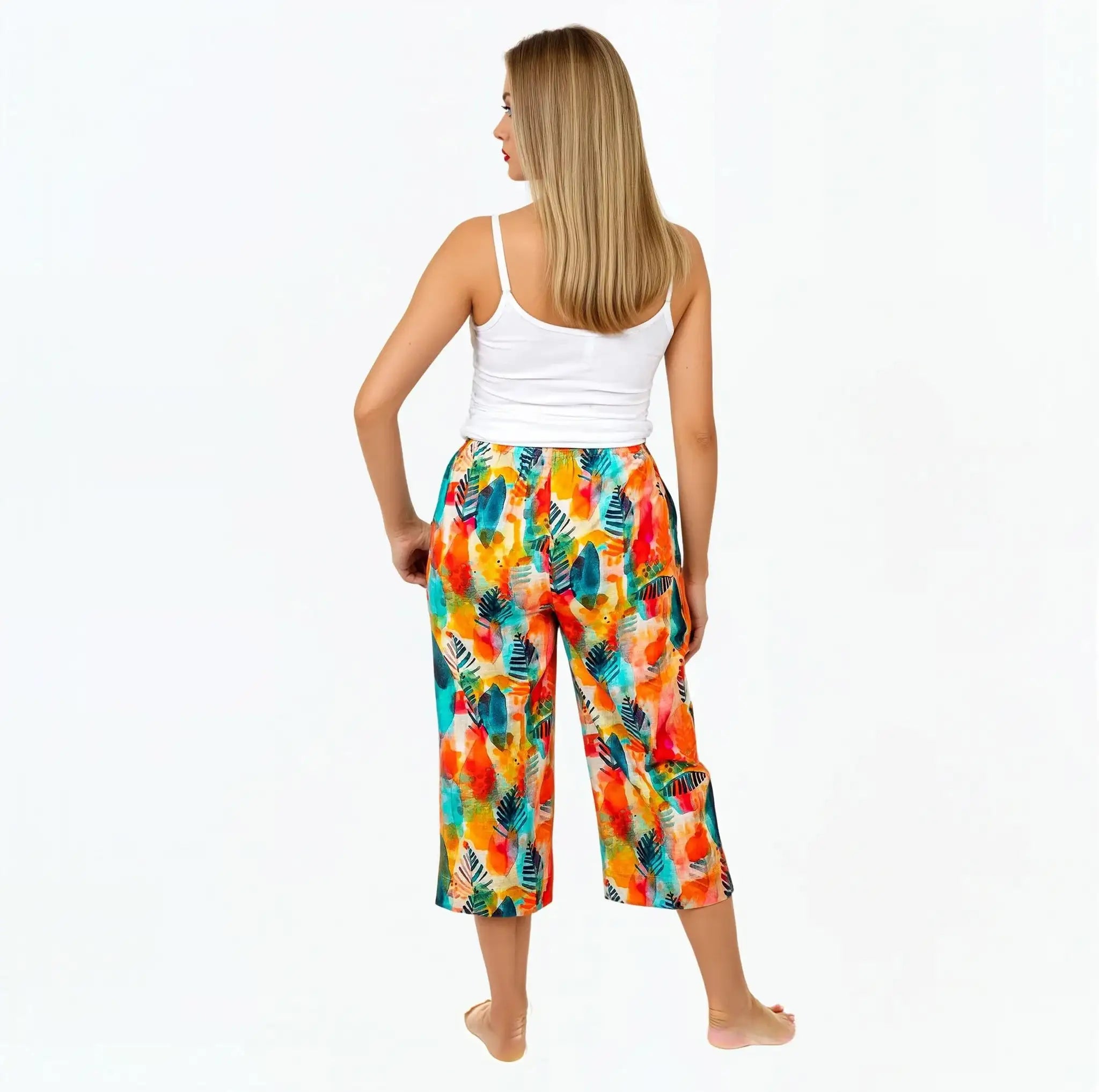 Woman wearing Claire Powell eco-friendly Tropicana print pants and white tank top, back view