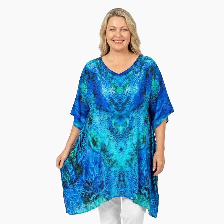 Woman wearing Claire Powell Plus Size Kaftan Top in Aquatica print, vibrant blue, front view