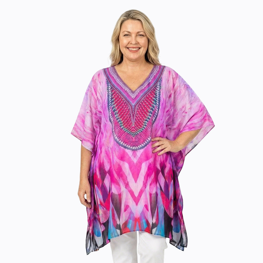 Woman wearing Claire Powell Plus Size Kaftan Top in Brazen print, vibrant pink and blue, front view
