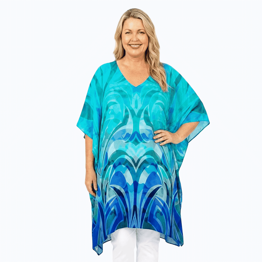 Woman wearing Claire Powell Plus Size Kaftan Top in Waves print, turquoise fading to navy, front view, arm raised