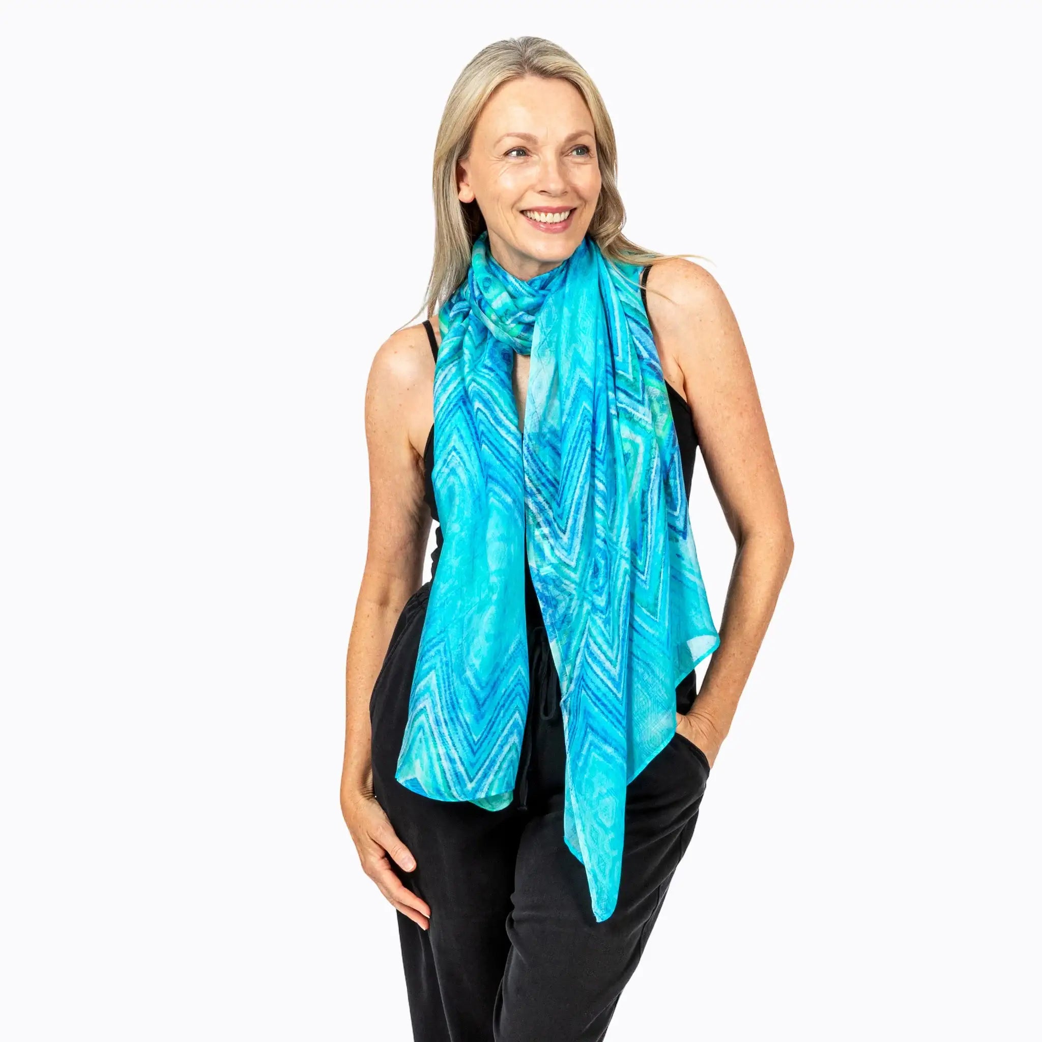 Woman modeling Claire Powell blue patterned scarf, eco-friendly elegant women's accessory