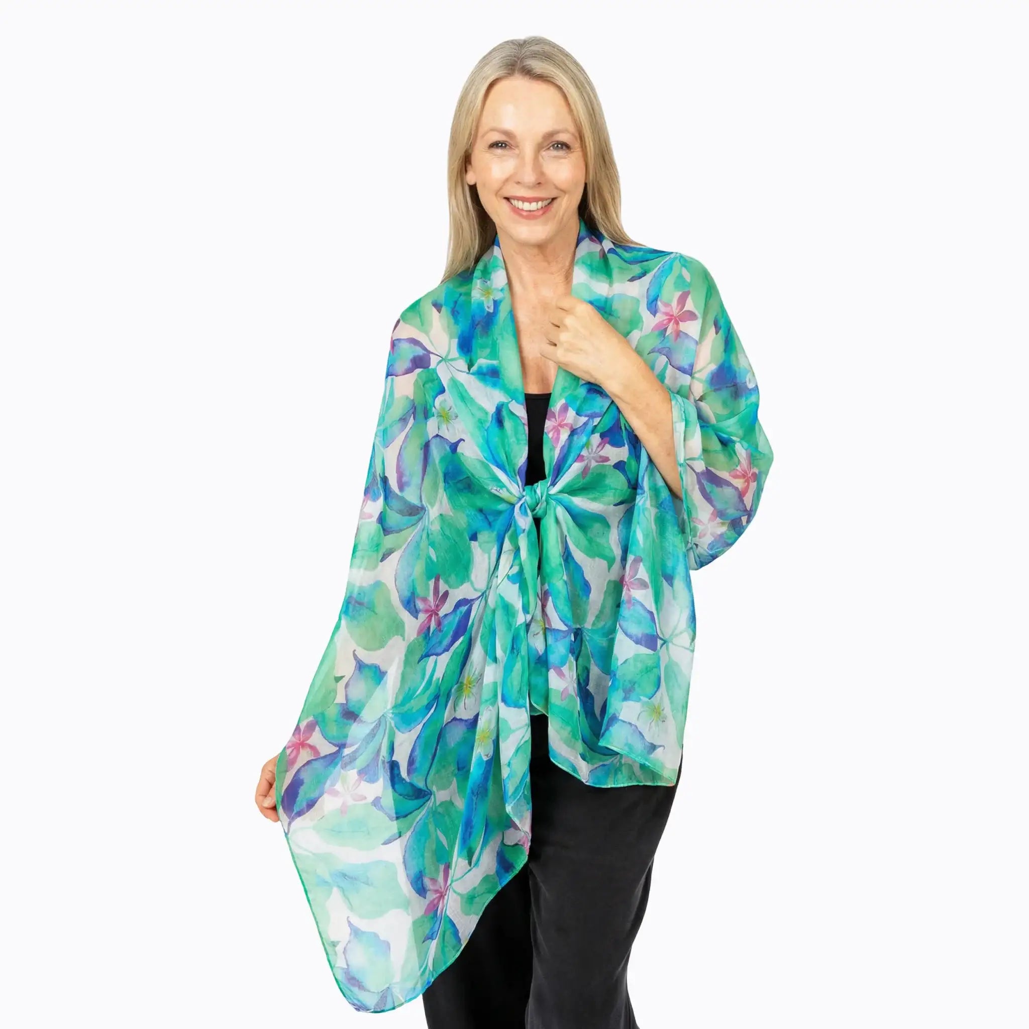 Woman wearing a Claire Powell silk scarf with green and purple floral print, smiling.