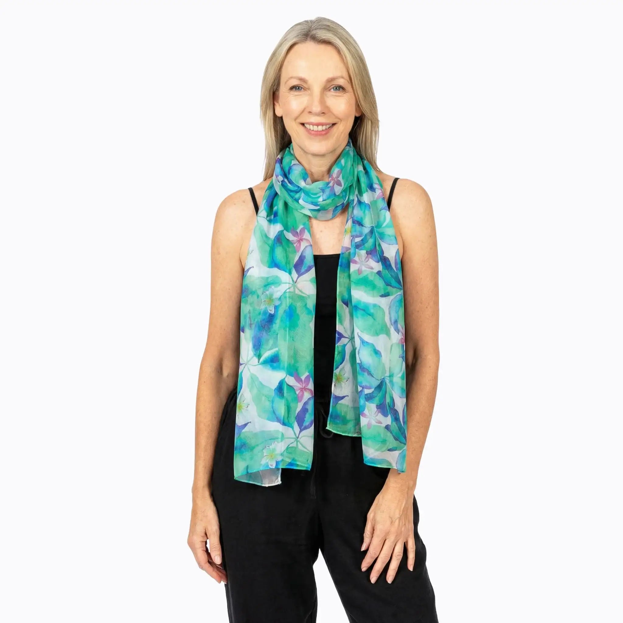 Woman wearing a floral aqua silk scarf from Claire Powell over a black sleeveless top