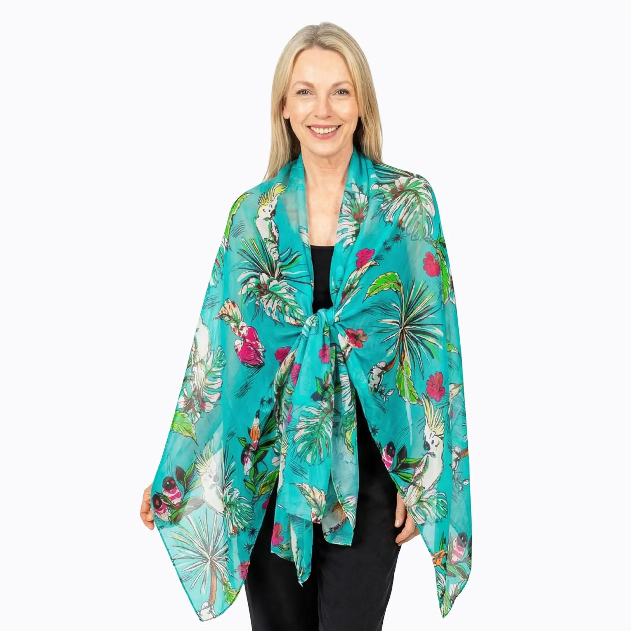 Woman wearing a Claire Powell teal silk scarf with tropical bird and leaf print