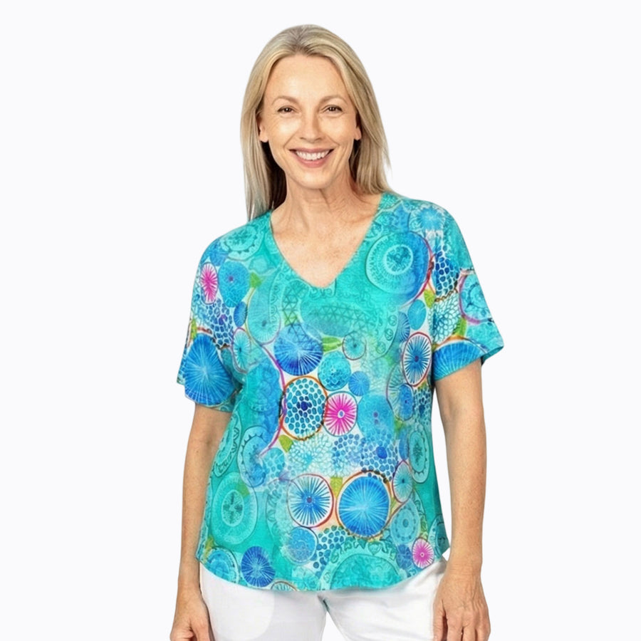 Woman wearing Claire Powell V-Neck T-Shirt in Kaleido print, magenta, blue and teal kaleidoscope, front view