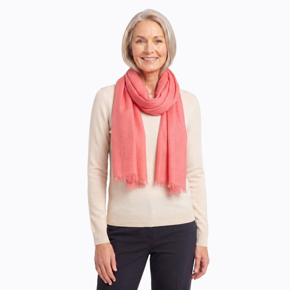 Woman styling a peach Claire Powell silk wool scarf