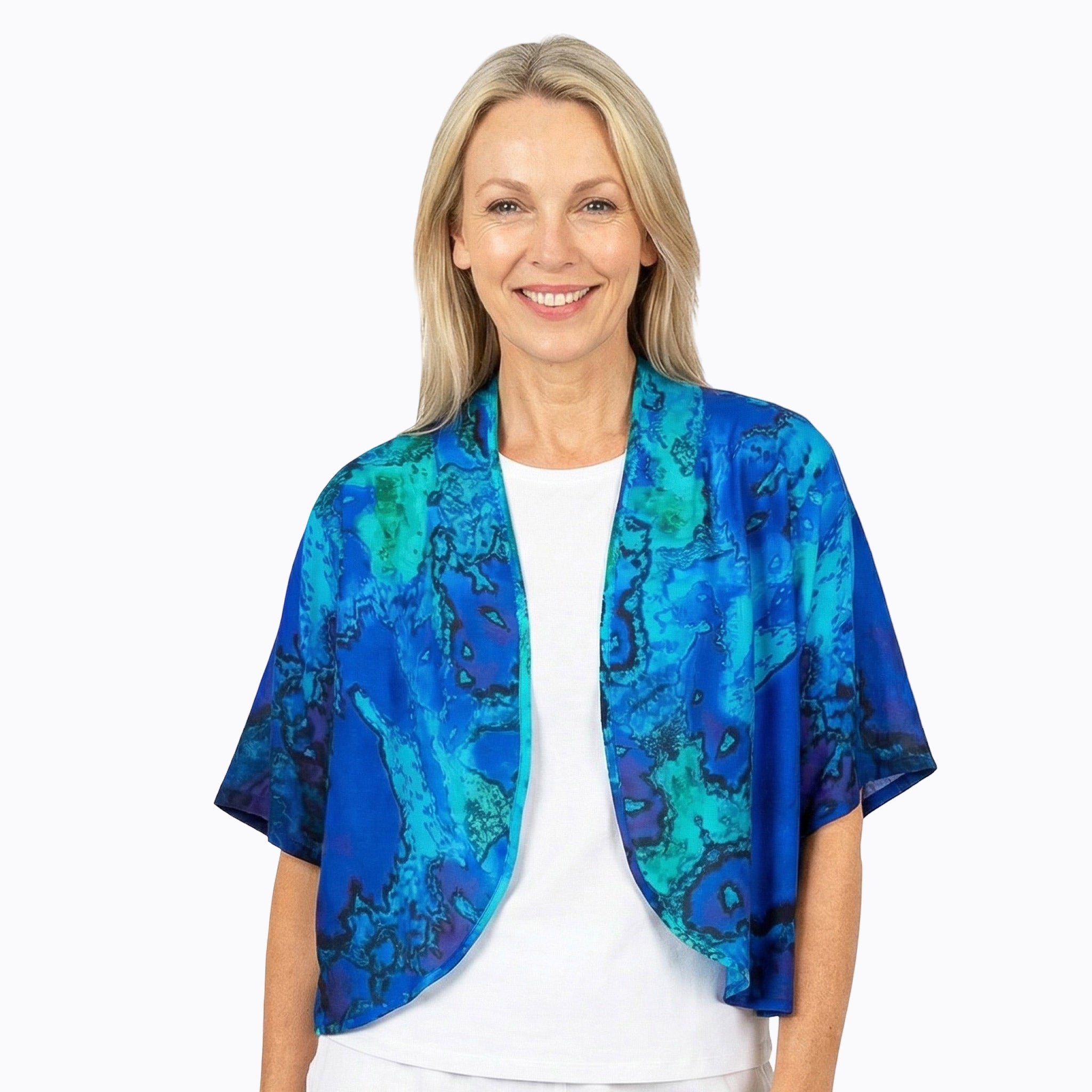 Woman wearing Claire Powell blue bolero jacket with abstract reef print, eco-friendly fashion.