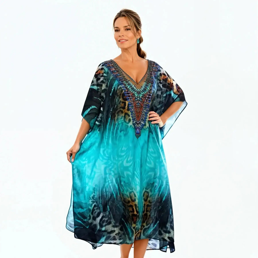 Woman wearing a vibrant blue jungle print kaftan dress from Claire Powell