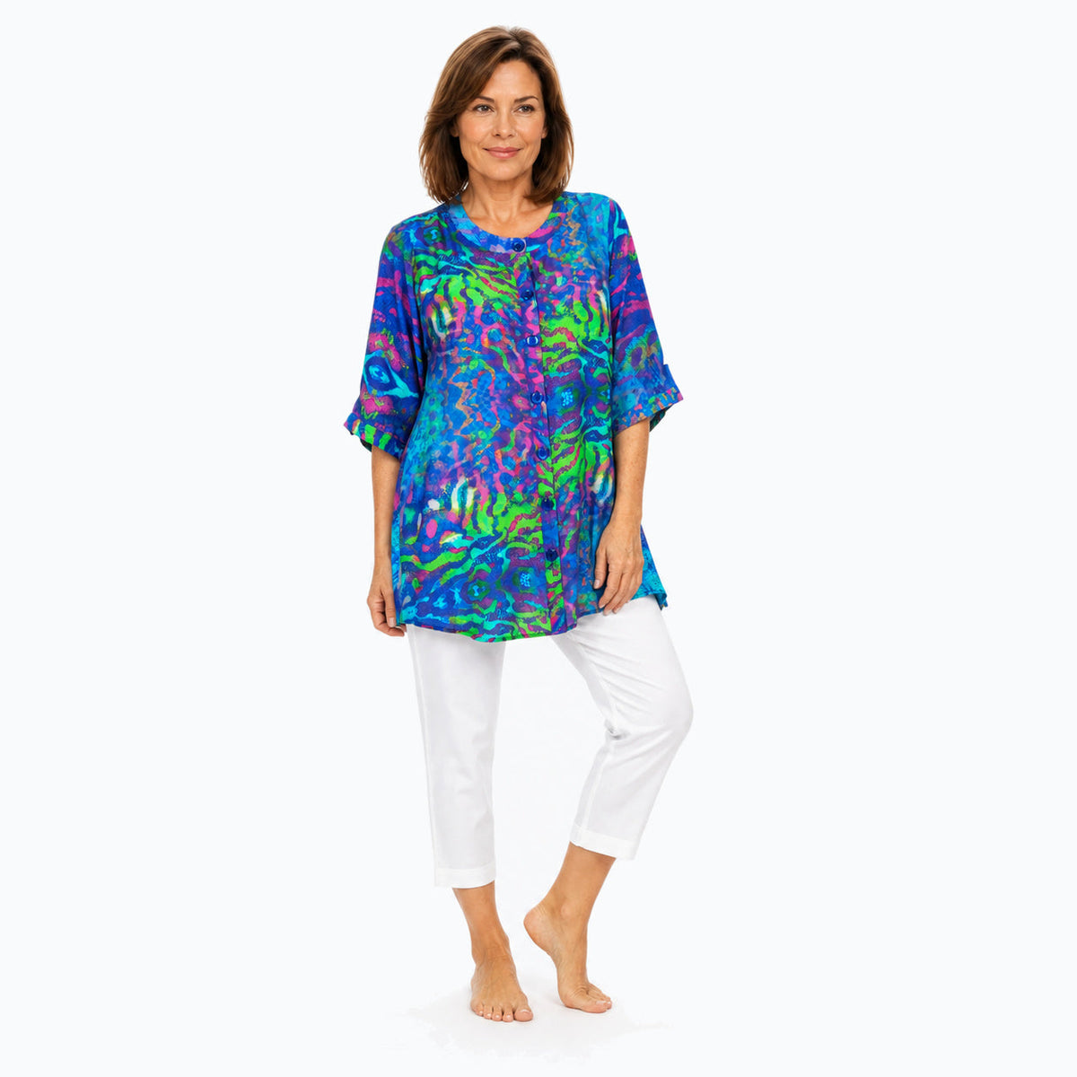 Woman wearing the Claire Powell Mirage A-Line Tunic Shirt with white capri pants, full-body three-quarter view
