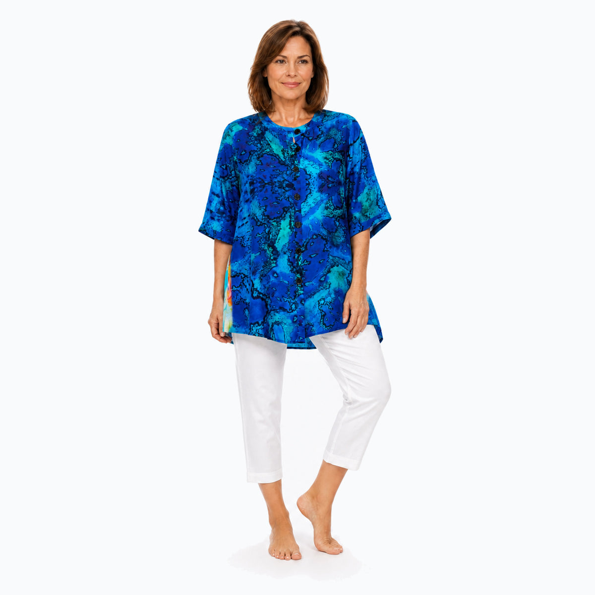 Woman wearing the Claire Powell Reef A-Line Tunic Shirt with white capri pants, full-body view