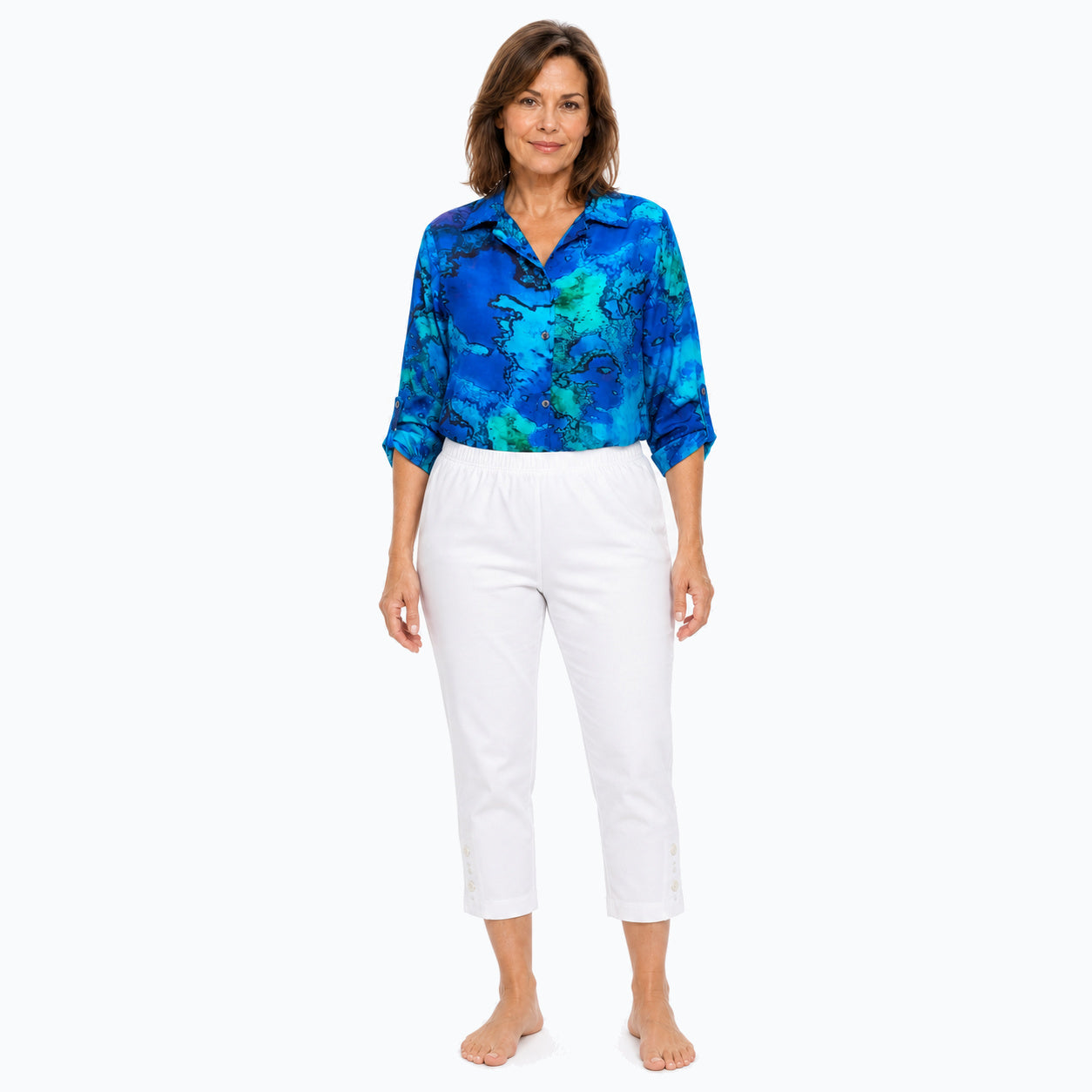 Woman wearing the Claire Powell Reef Collared Silk Shirt with white capri pants, front tucked full-body view