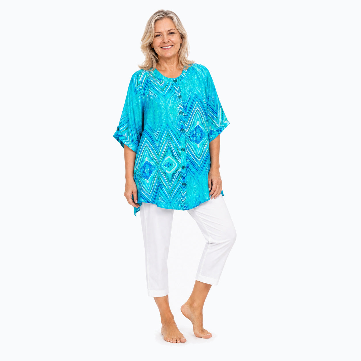 Woman wearing the Claire Powell Serenity A-Line Tunic Shirt with white capri pants, full-body three-quarter view