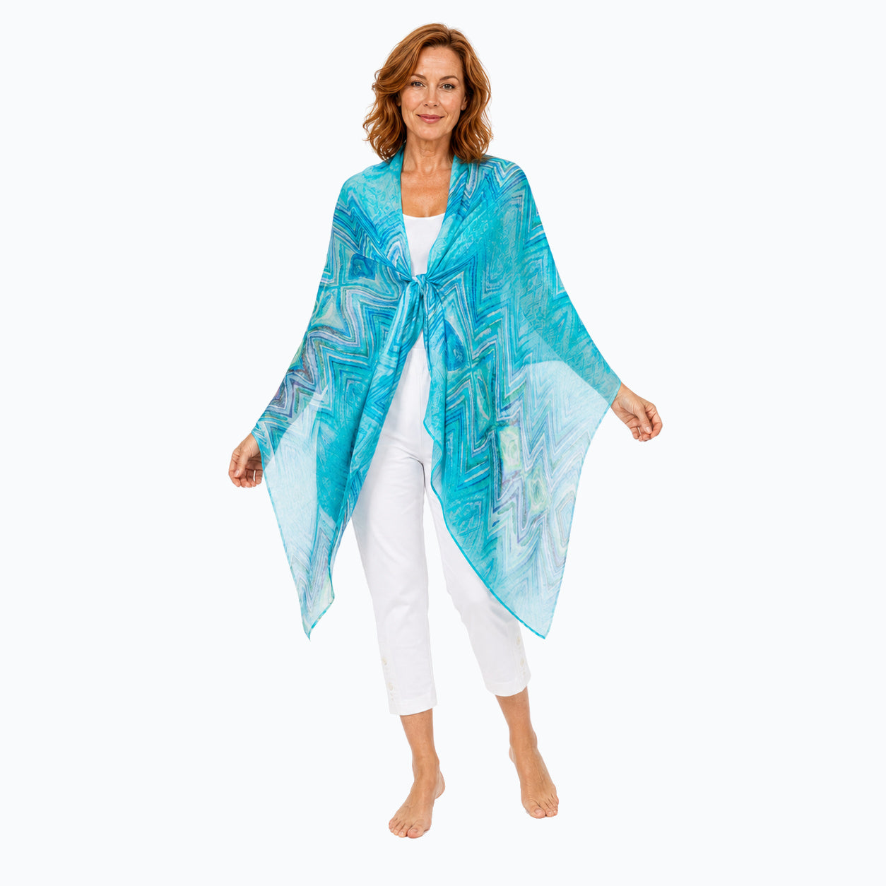 Woman wearing the Claire Powell Serenity silk scarf, tied shawl, full-body view with white capris and bare feet