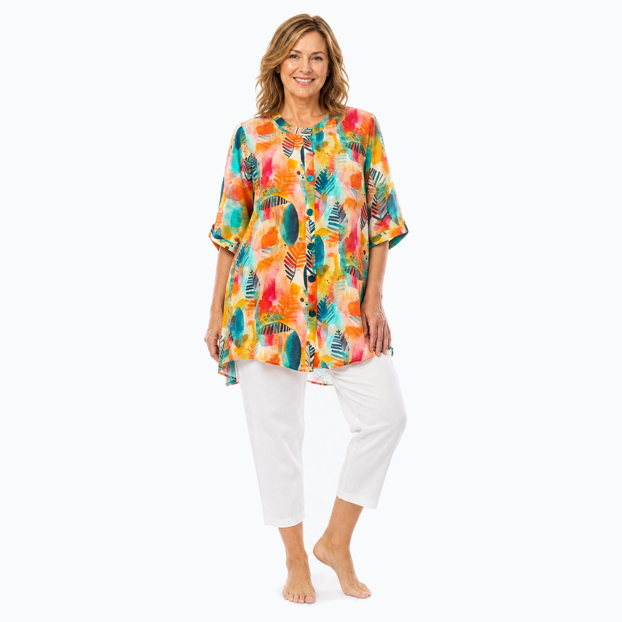 Woman wearing the Claire Powell Tropicana A-Line Tunic Shirt with white capri pants, full-body view