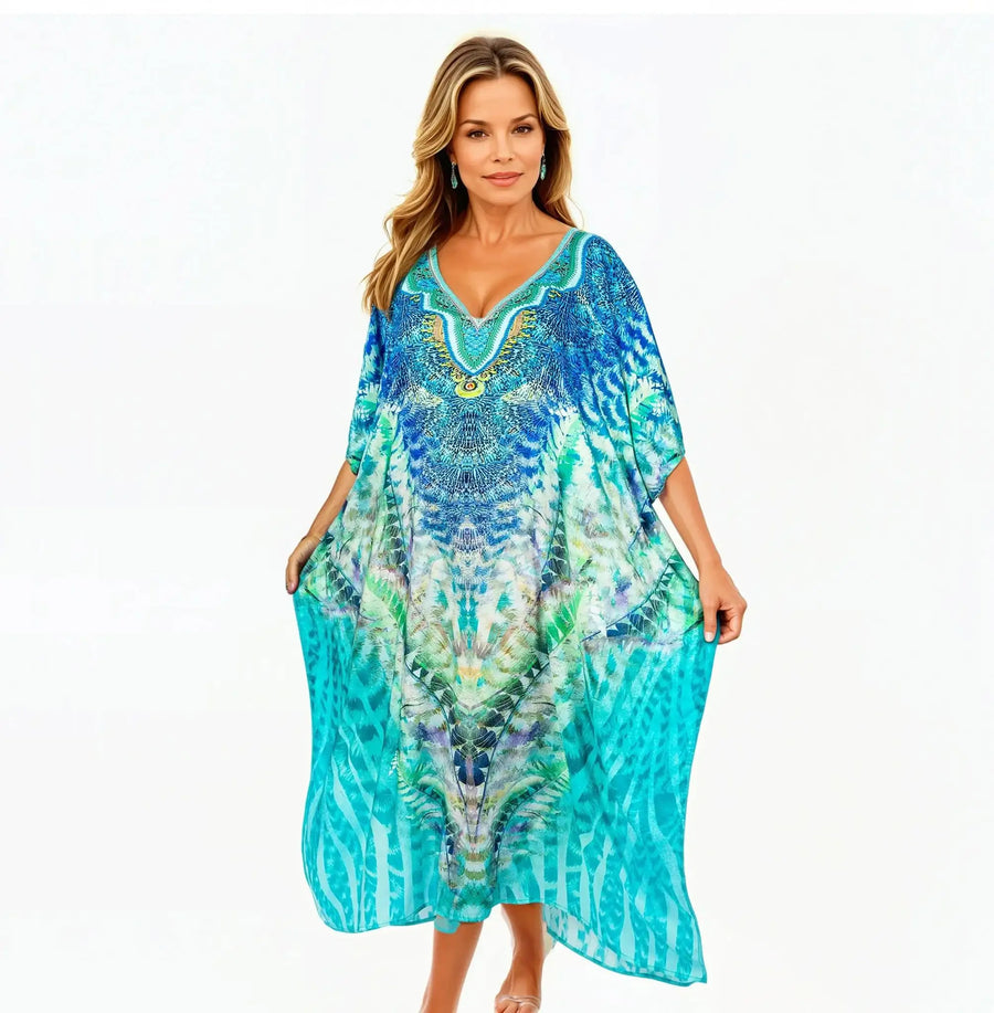 Woman wearing Claire Powell marine blue kaftan dress with vibrant pattern, elegant and eco-friendly