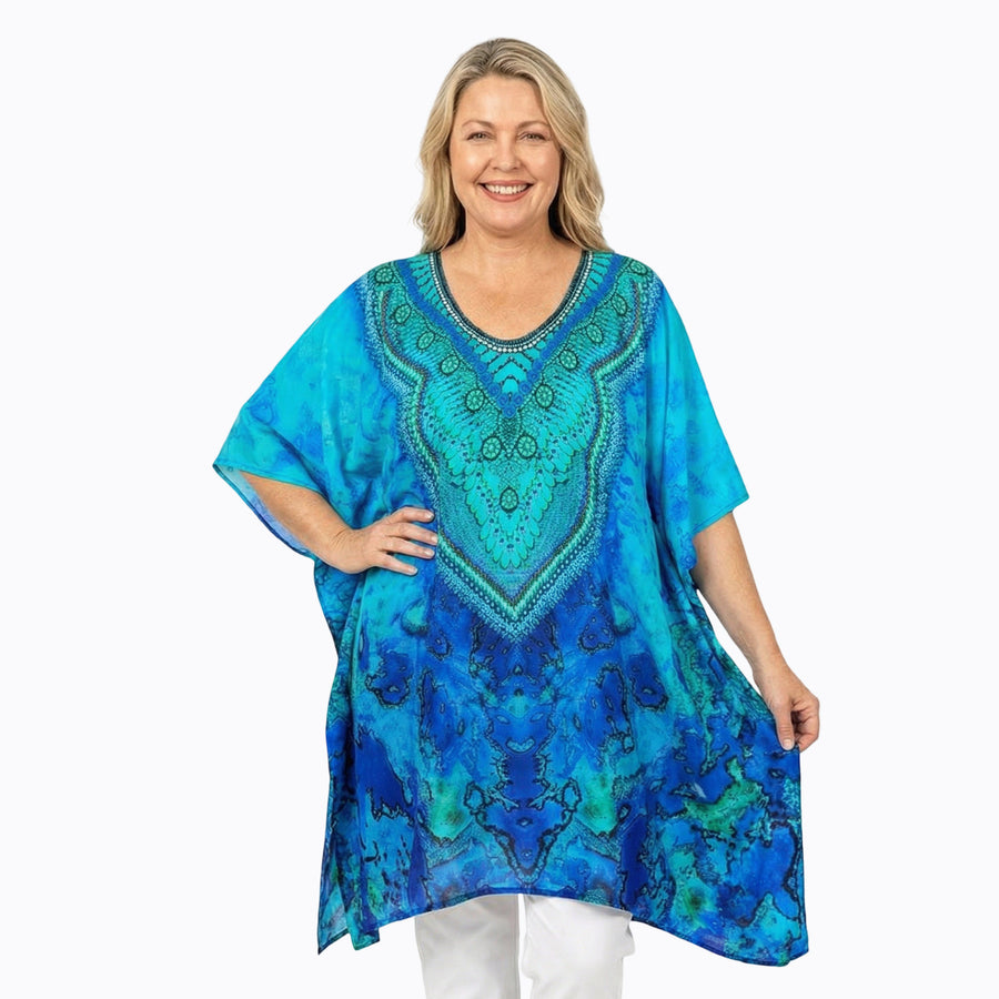 Woman wearing Claire Powell Plus Size Kaftan Top in Reef print, blue and teal watercolour, front view, styled fashion shot