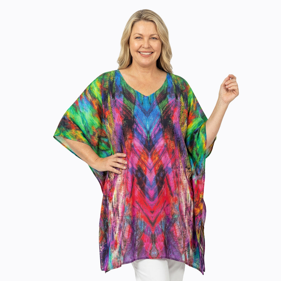 Woman wearing Claire Powell Plus Size Kaftan Top in Carnival print, vibrant multicolour, front view, alternate pose