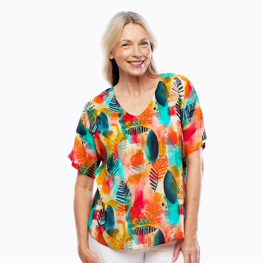 Woman wearing Claire Powell V-Neck T-Shirt in Tropicana print, fuchsia, orange and turquoise tropical, front view