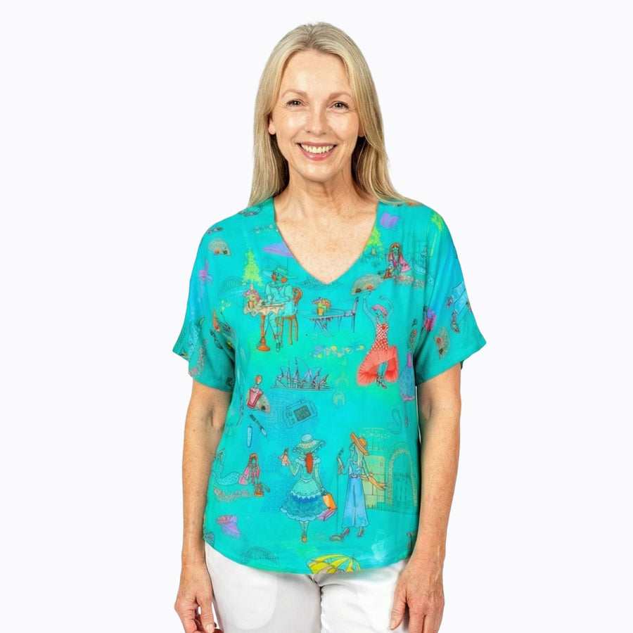 Woman wearing Claire Powell V-Neck T-Shirt in Sirens print, deep ocean blue, emerald and teal, front view