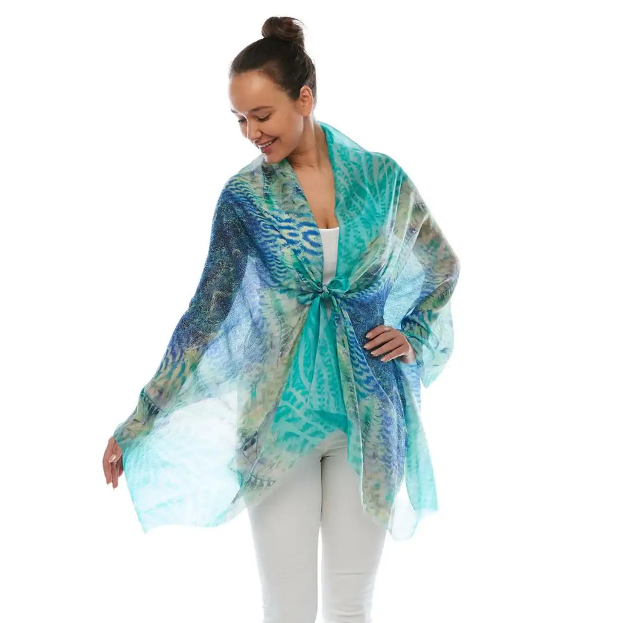 Woman wearing a sheer blue and turquoise patterned scarf from Claire Powell.