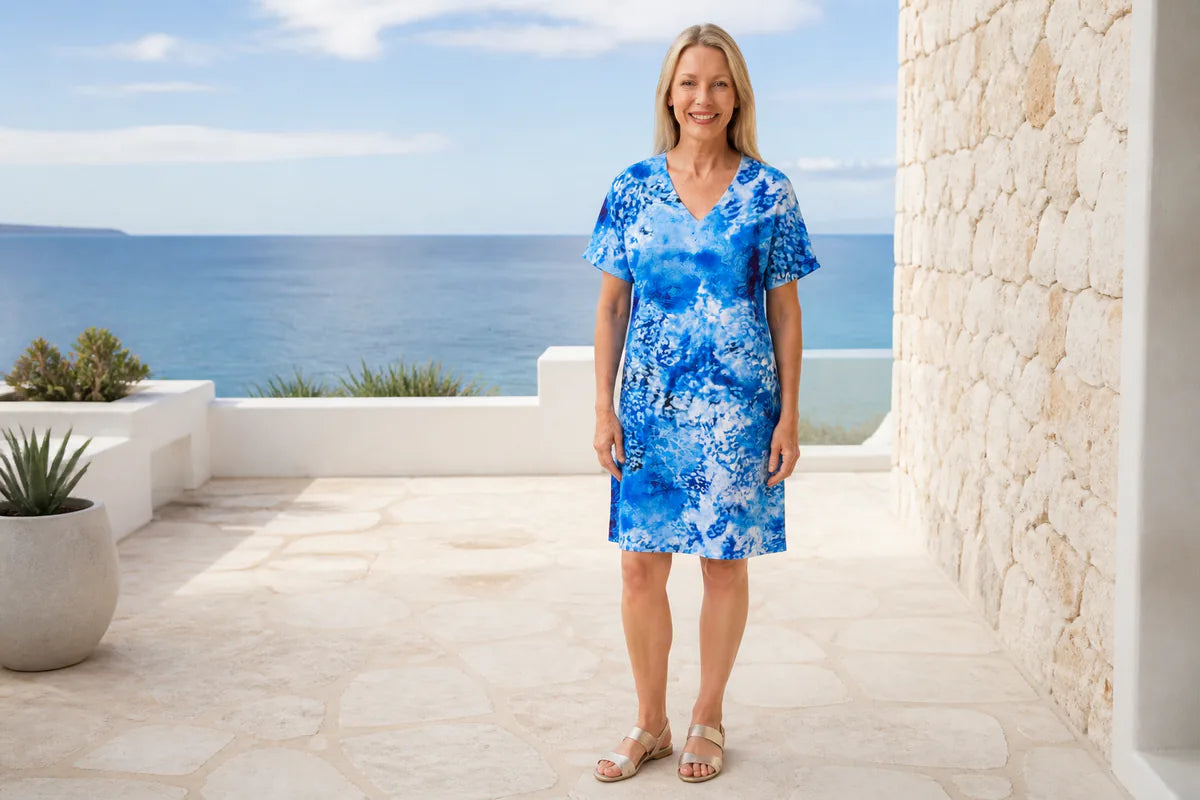 Mature model wearing the Claire Powell Snowcat shift dress at a coastal resort