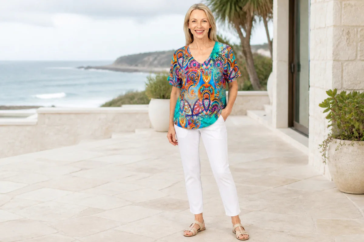 Mature model wearing the Claire Powell Mosaic V-neck T-Shirt at a coastal resort