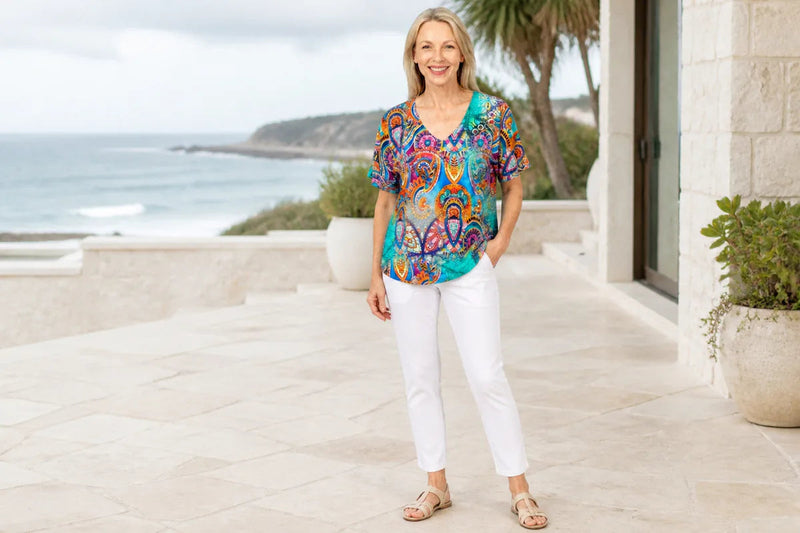 Mature model wearing the Claire Powell Mosaic V-neck T-Shirt at a coastal resort